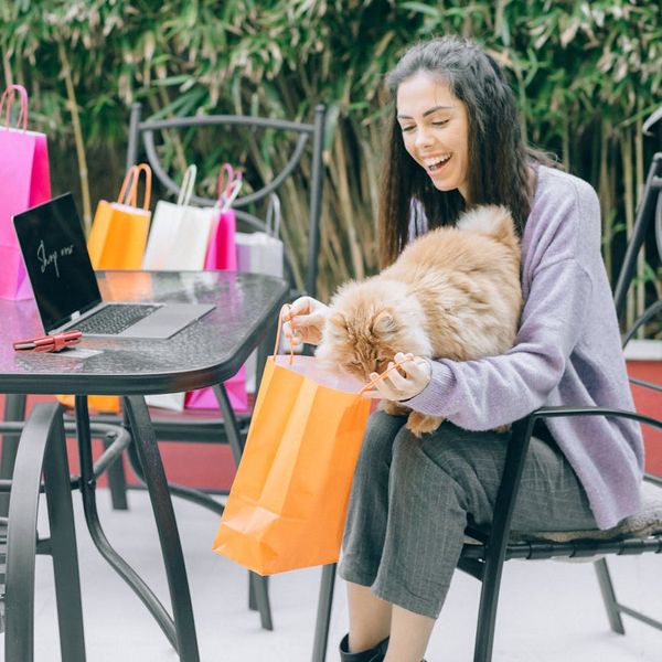 A person smiling while stretching gently in a bright, modern living room.
