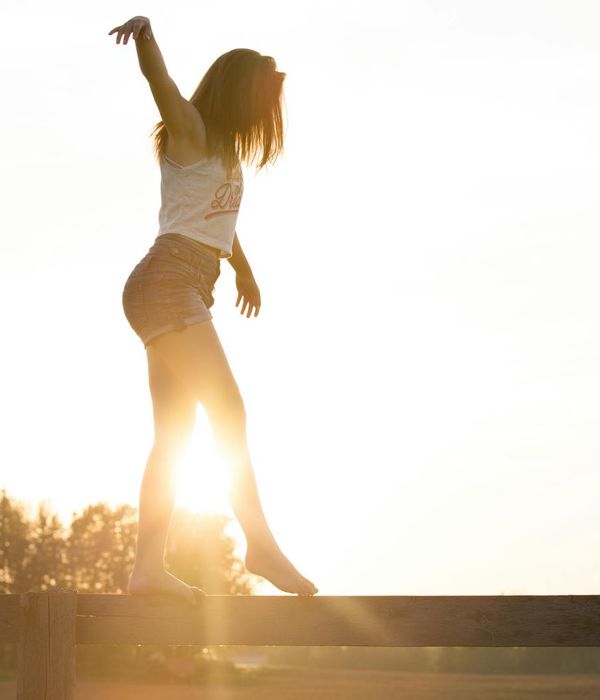 A silhouette of a person stretching against a sunrise, feeling energetic.
