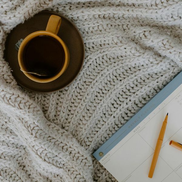 Calendar with a marked day for practice, next to a cup of tea.